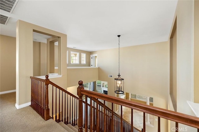 hall with carpet floors and a chandelier