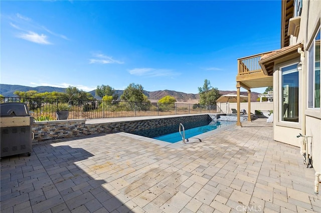 view of swimming pool featuring a mountain view, a patio, and area for grilling