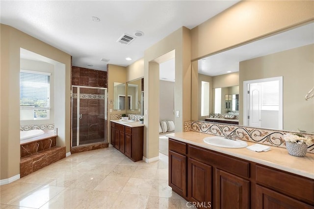 bathroom featuring shower with separate bathtub and vanity