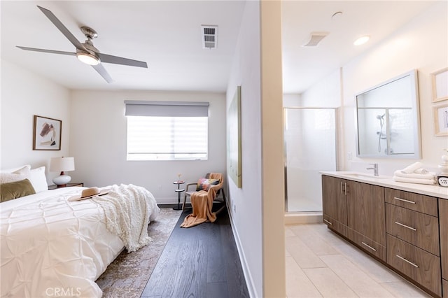 bedroom featuring light hardwood / wood-style flooring, ceiling fan, and sink