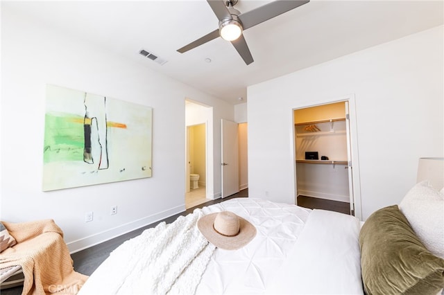 bedroom with a walk in closet, ceiling fan, dark hardwood / wood-style floors, connected bathroom, and a closet