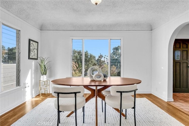 dining area with hardwood / wood-style floors and ornamental molding