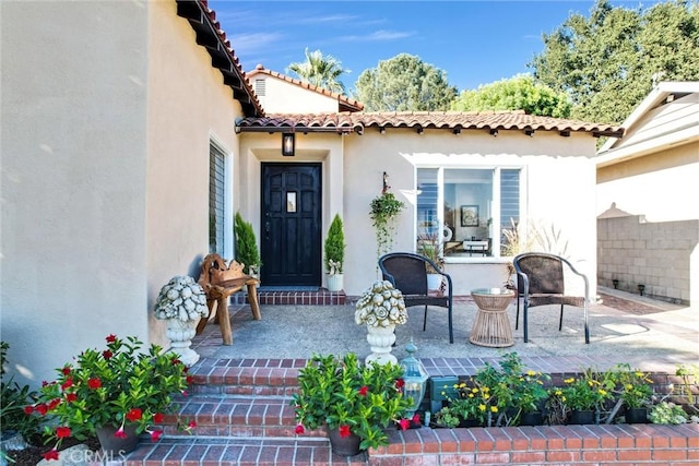 view of exterior entry with a patio area