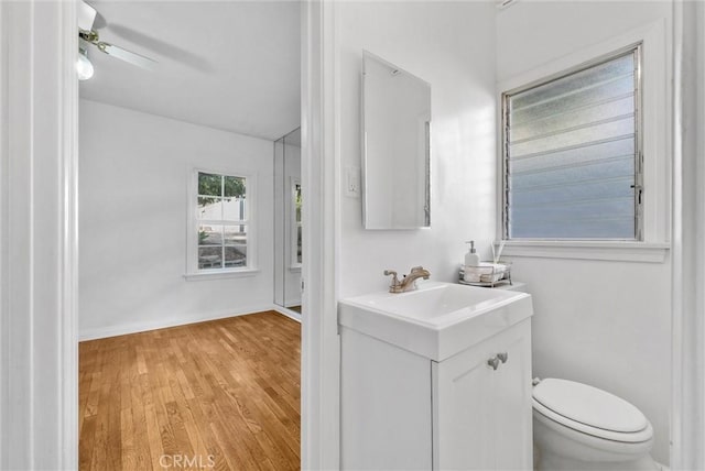 bathroom featuring toilet, ceiling fan, hardwood / wood-style flooring, and vanity