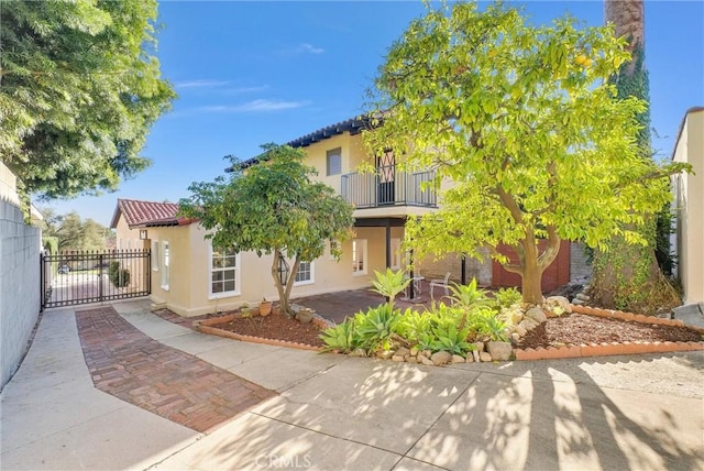 view of front of property featuring a balcony and a patio