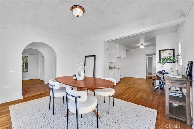 dining area with a textured ceiling and hardwood / wood-style flooring