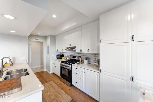 kitchen featuring light hardwood / wood-style floors, white cabinetry, stainless steel range with gas cooktop, and sink