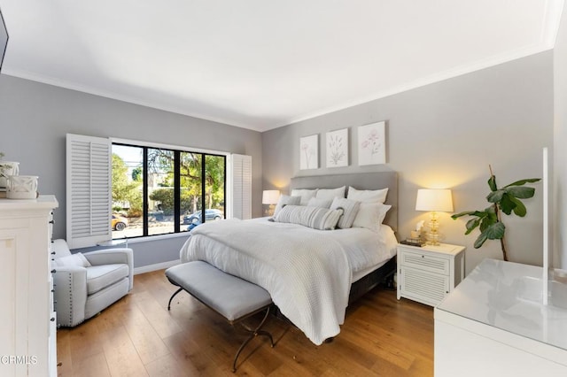 bedroom with hardwood / wood-style floors and crown molding