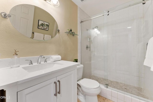 bathroom with an enclosed shower, vanity, toilet, and tile patterned flooring