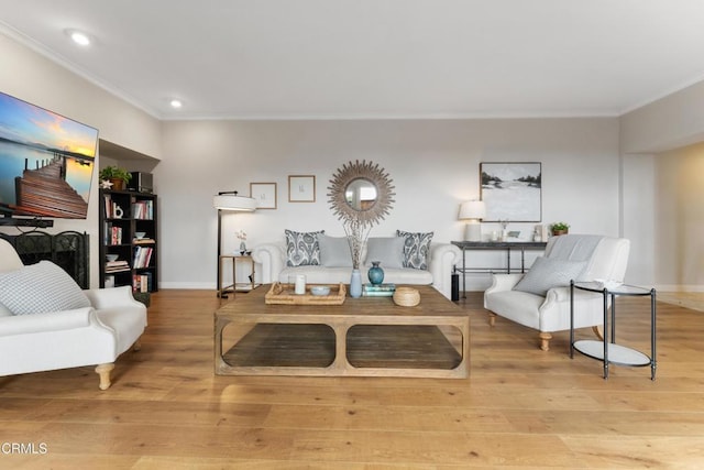 living room with light hardwood / wood-style flooring and ornamental molding