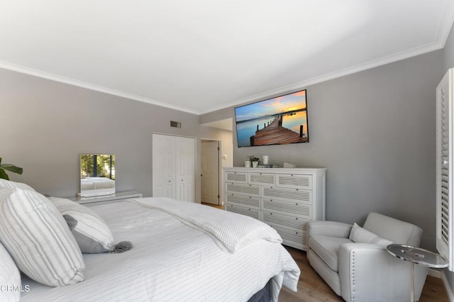 bedroom featuring hardwood / wood-style flooring, a closet, and ornamental molding