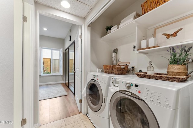 washroom with washing machine and clothes dryer and light hardwood / wood-style floors