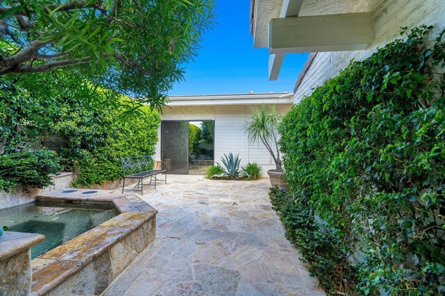 view of patio / terrace with an in ground hot tub