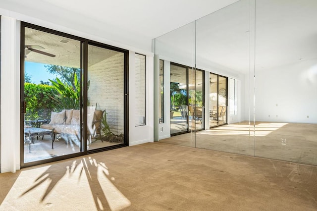 entryway with light colored carpet, plenty of natural light, and ceiling fan