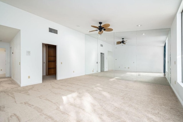 carpeted spare room with ceiling fan