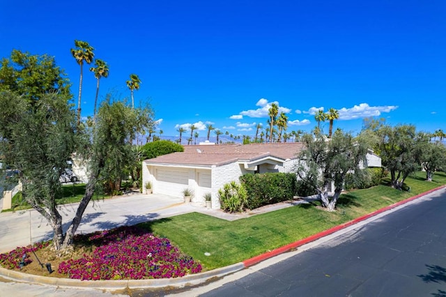 ranch-style house featuring a garage and a front lawn