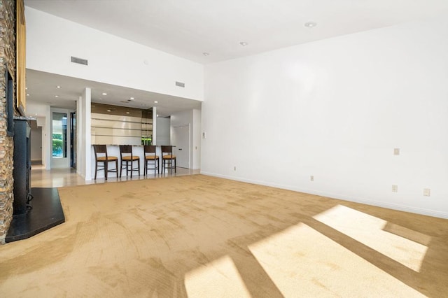 carpeted spare room with a high ceiling