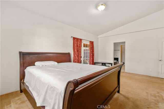 bedroom with vaulted ceiling and light colored carpet