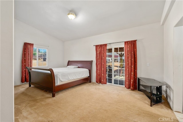 bedroom featuring lofted ceiling, access to exterior, and light colored carpet