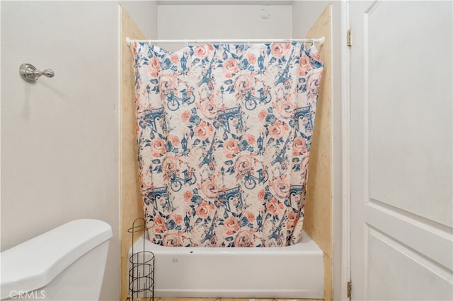 bathroom featuring shower / tub combo with curtain and toilet