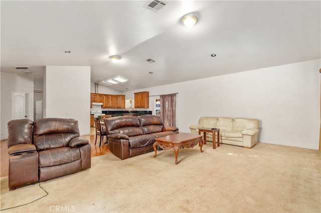 carpeted living room featuring vaulted ceiling