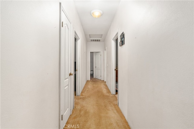 hall with light colored carpet