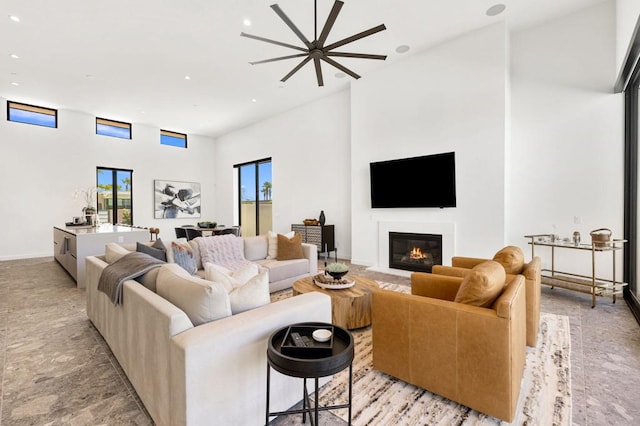 living room with a towering ceiling and ceiling fan