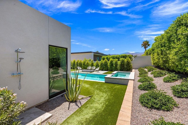 view of pool with an in ground hot tub and a lawn