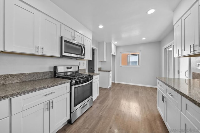 kitchen featuring light hardwood / wood-style flooring, white cabinets, and appliances with stainless steel finishes