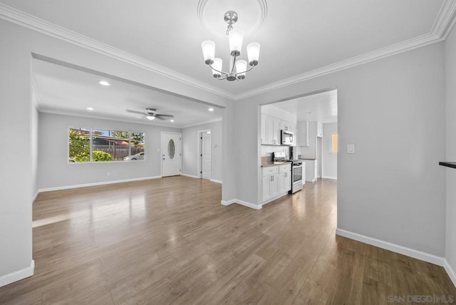 unfurnished living room featuring hardwood / wood-style floors, ceiling fan with notable chandelier, and ornamental molding