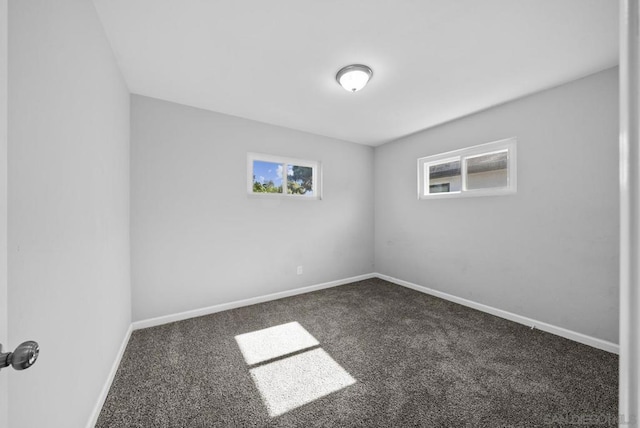 spare room with dark carpet