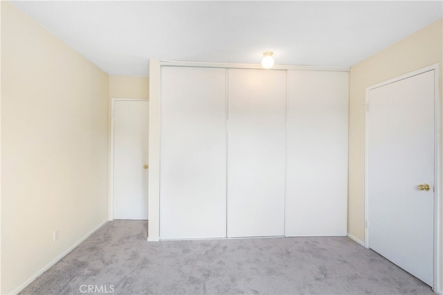 unfurnished bedroom with a closet and light carpet