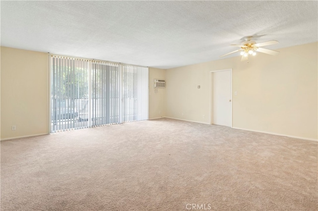 unfurnished room with carpet, an AC wall unit, a textured ceiling, and ceiling fan