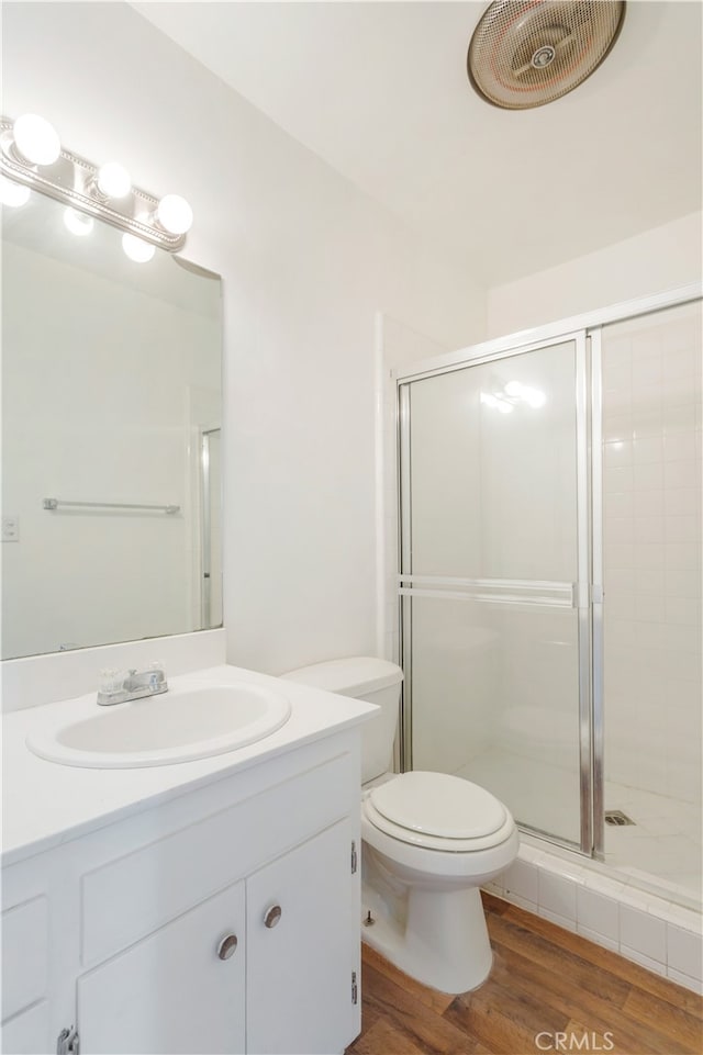 bathroom featuring toilet, hardwood / wood-style floors, walk in shower, and vanity