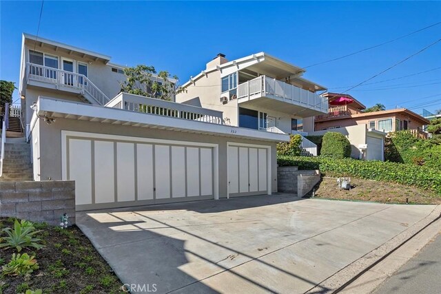 view of front of property featuring a garage and a balcony