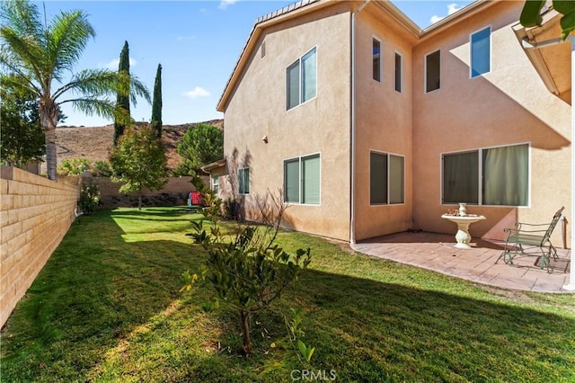 rear view of house with a lawn and a patio area