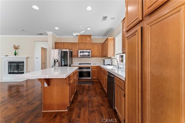 kitchen with dark hardwood / wood-style floors, tile countertops, a center island, a breakfast bar, and stainless steel appliances