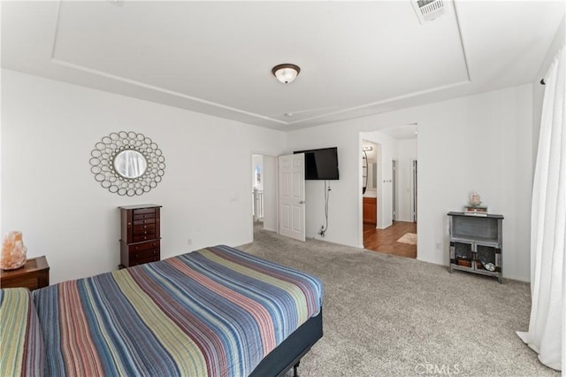 bedroom featuring carpet floors and a raised ceiling