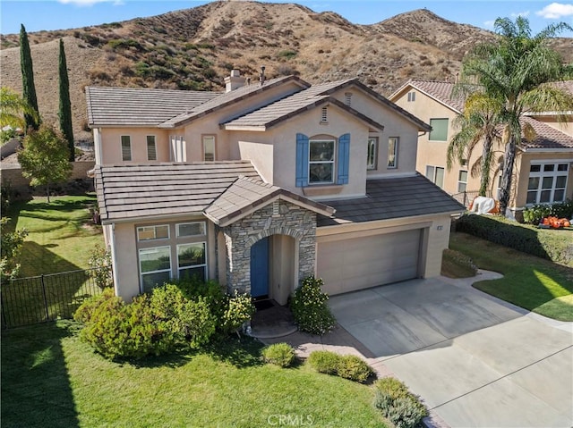 view of front of home with a front yard, a mountain view, and a garage