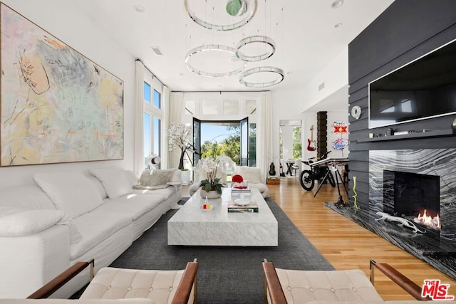 living room with a high end fireplace and hardwood / wood-style floors