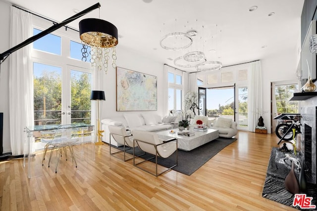 living room featuring a high end fireplace, hardwood / wood-style flooring, and a wealth of natural light