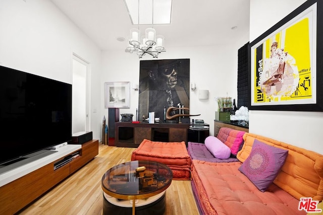 living room with hardwood / wood-style floors and a notable chandelier