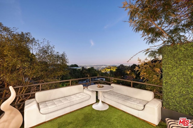 patio terrace at dusk featuring a balcony