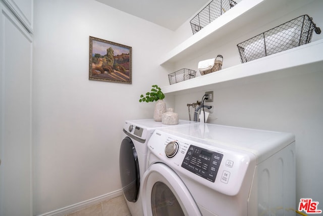 laundry room with washing machine and dryer and light tile patterned floors