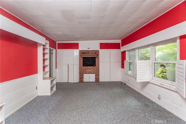 unfurnished living room with a fireplace and dark carpet