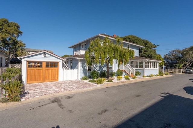 view of front facade featuring a garage and a sunroom