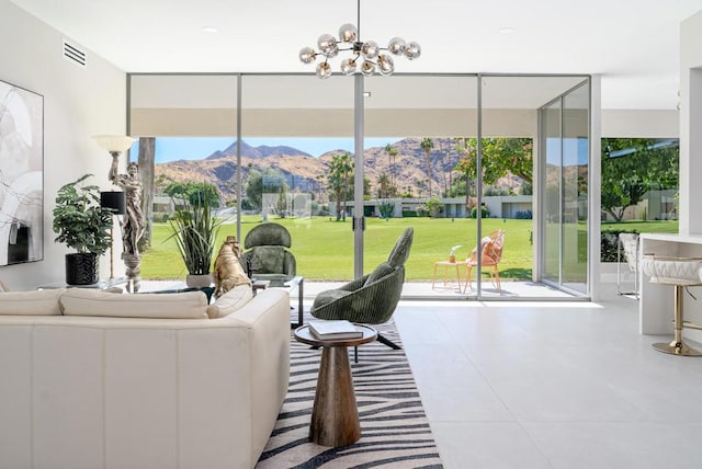 sunroom / solarium with a mountain view and an inviting chandelier