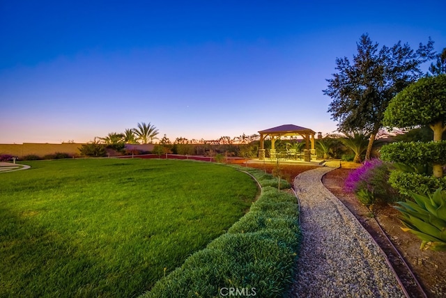 yard at dusk with a gazebo