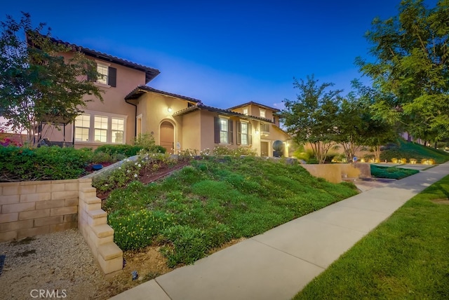 mediterranean / spanish house with a tiled roof and stucco siding