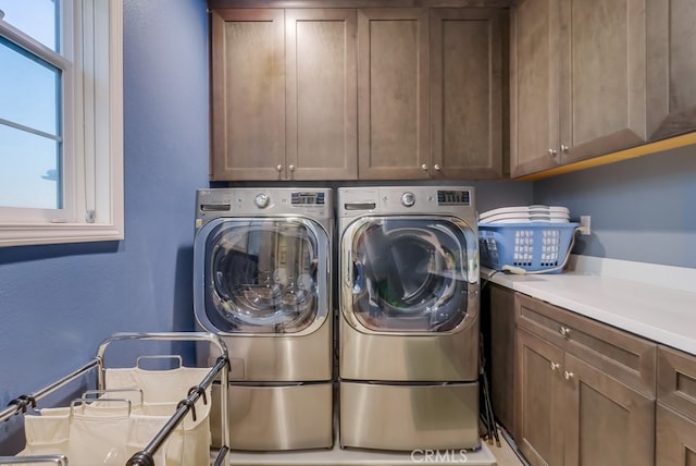 laundry room with washing machine and dryer and cabinets